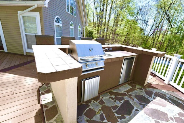 exterior space with a wooden deck and area for grilling