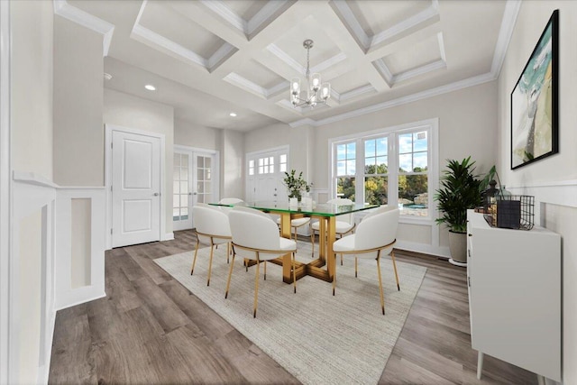 dining room with wood finished floors, beamed ceiling, a chandelier, french doors, and coffered ceiling