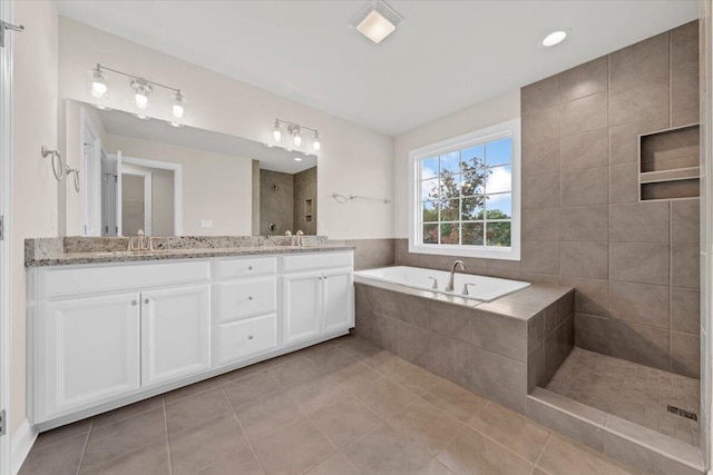 full bathroom with double vanity, a garden tub, tile patterned flooring, a sink, and tiled shower