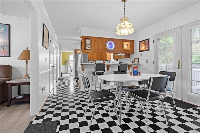 dining area with ornamental molding, tile patterned floors, and baseboards