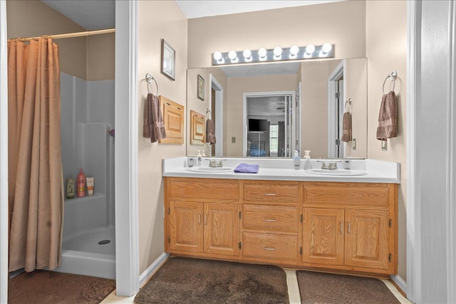 bathroom with a shower with curtain, double vanity, and baseboards