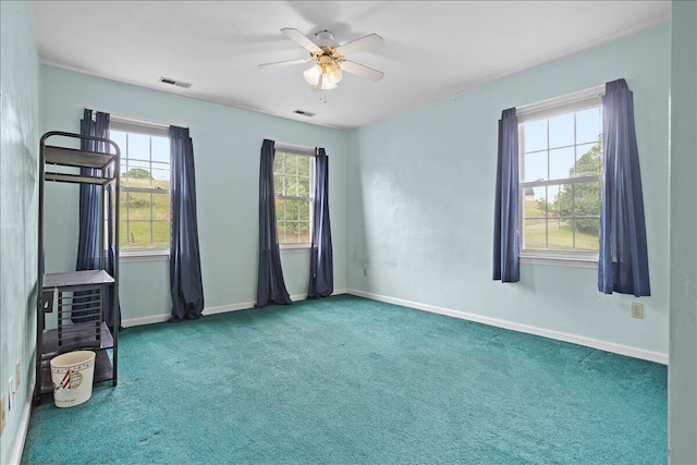 spare room with carpet, baseboards, and a ceiling fan