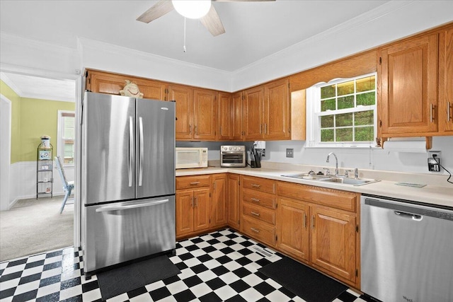 kitchen featuring stainless steel appliances, a sink, tile patterned floors, light countertops, and ornamental molding