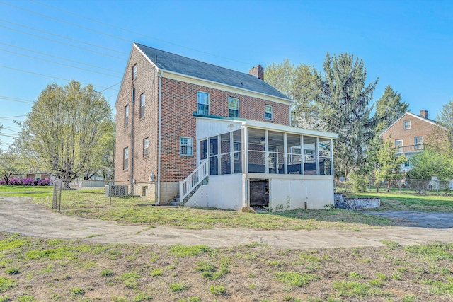 1112 Highland Rd, Salem, VA 24153 - back of house featuring a sunroom, brick siding, a chimney, and central AC unit