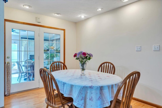 dining area with light wood-type flooring and baseboards