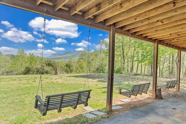 view of patio featuring a wooded view and a mountain view