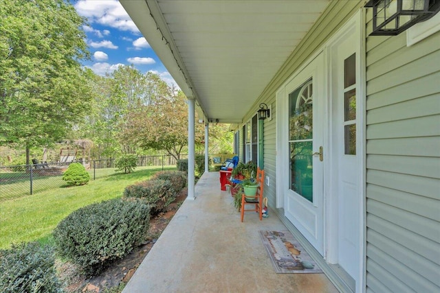 view of patio featuring a porch and fence