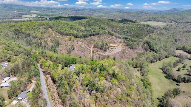bird's eye view with a wooded view