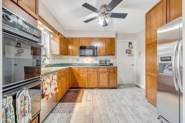 2626 Avenham Ave SW, Roanoke, VA 24014 - kitchen with black appliances, light wood-type flooring, brown cabinets, a ceiling fan, and baseboards