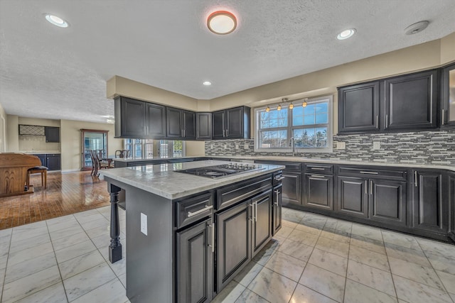 kitchen with black electric cooktop, a textured ceiling, and decorative backsplash