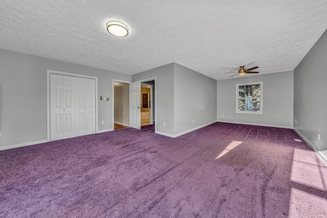 interior space with dark colored carpet, a textured ceiling, a ceiling fan, and baseboards