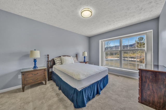 bedroom with baseboards, carpet, and a textured ceiling