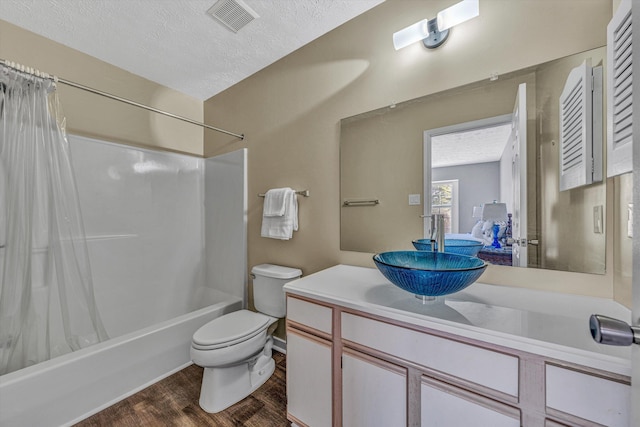 bathroom featuring shower / bathtub combination with curtain, wood finished floors, visible vents, toilet, and a textured ceiling