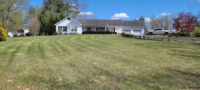 ranch-style home with a front lawn, aphalt driveway, and a garage
