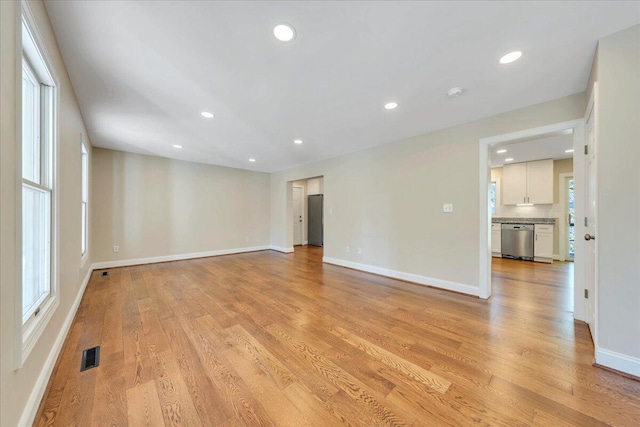 empty room with recessed lighting, light wood-type flooring, visible vents, and baseboards