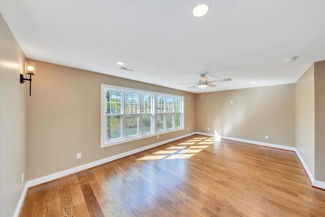 empty room with light wood finished floors, baseboards, and ceiling fan