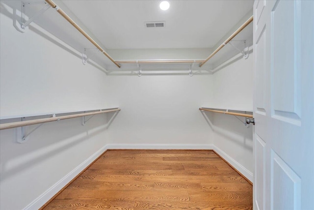 walk in closet with light wood finished floors and visible vents