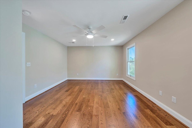 empty room featuring a ceiling fan, wood finished floors, baseboards, visible vents, and recessed lighting