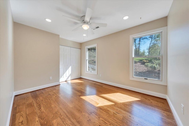 unfurnished bedroom featuring baseboards, wood finished floors, and visible vents