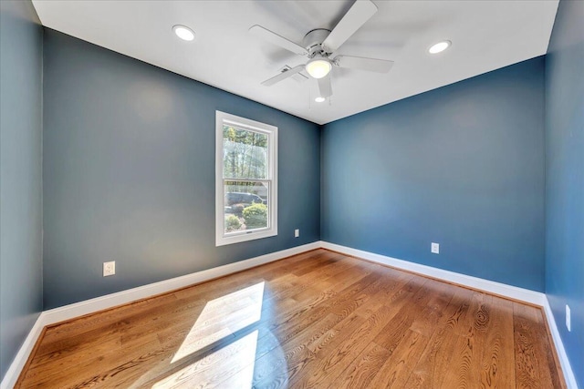 empty room with baseboards, a ceiling fan, and wood finished floors