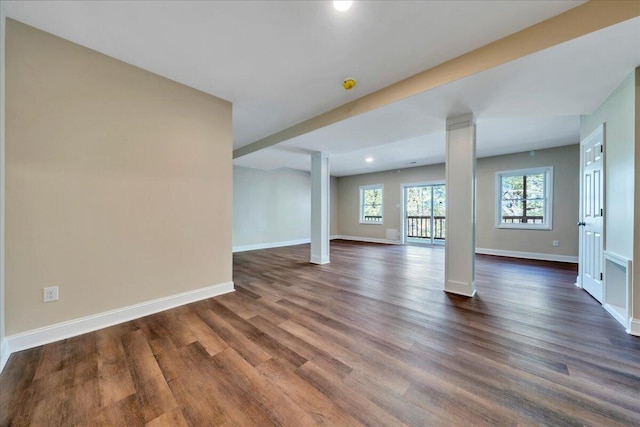 unfurnished living room with recessed lighting, dark wood finished floors, baseboards, and decorative columns