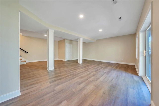 basement featuring baseboards, wood finished floors, and visible vents