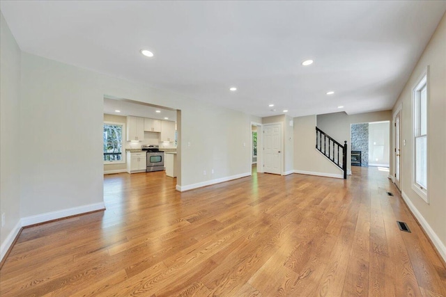 unfurnished living room featuring recessed lighting, stairway, visible vents, and light wood finished floors
