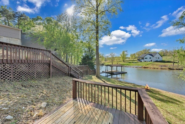 wooden deck featuring a lawn, a water view, and stairway