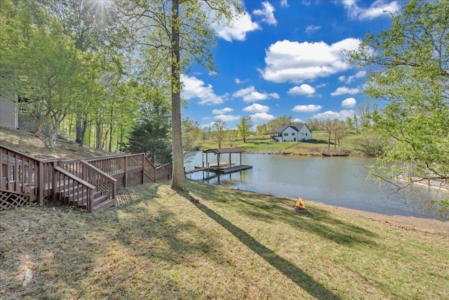 dock area with a lawn and a water view
