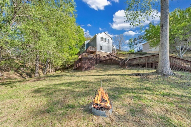 view of yard with stairway, a wooden deck, and an outdoor fire pit