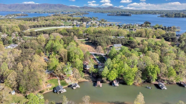 aerial view with a water and mountain view and a wooded view
