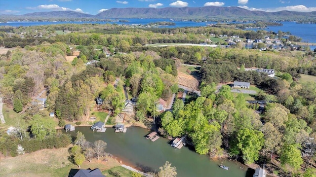aerial view with a wooded view and a water and mountain view