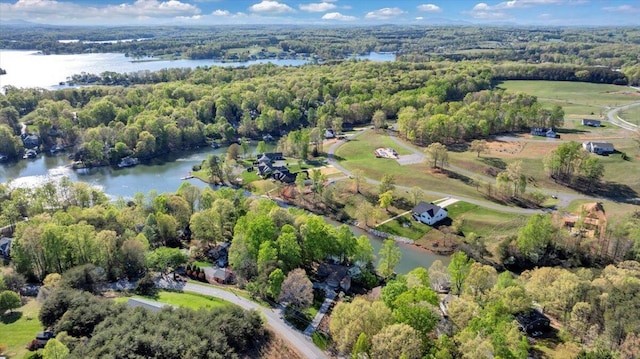 drone / aerial view with a wooded view and a water view