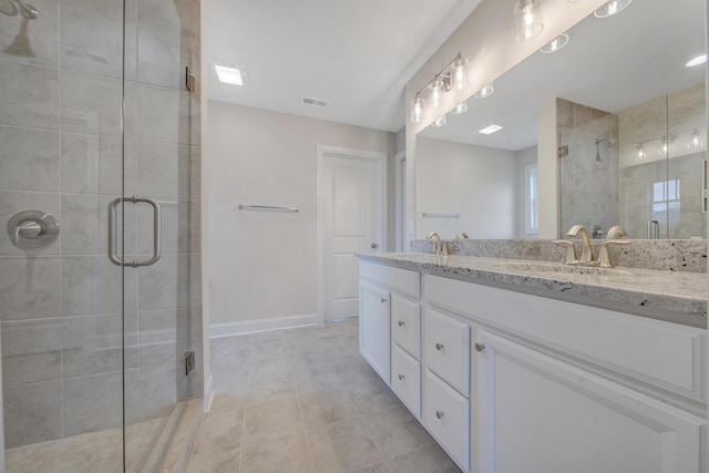 bathroom featuring a sink, double vanity, a stall shower, and visible vents