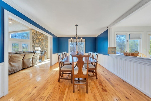 dining area with light wood-style floors, a notable chandelier, and crown molding