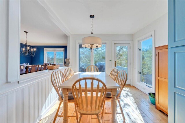 dining area with light wood-style flooring and an inviting chandelier
