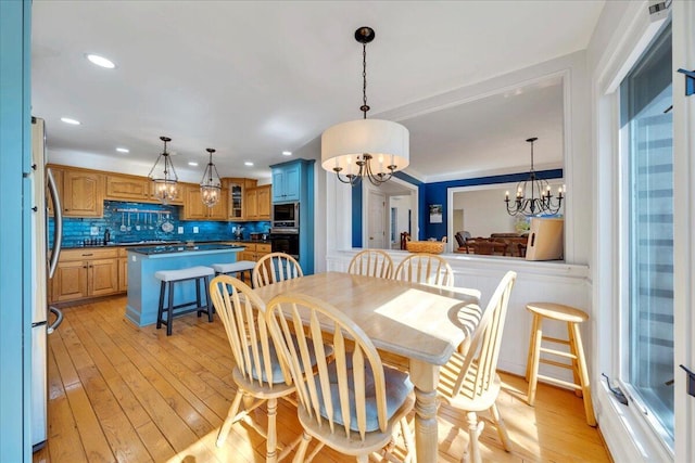 dining area featuring a notable chandelier, light wood-style floors, and recessed lighting
