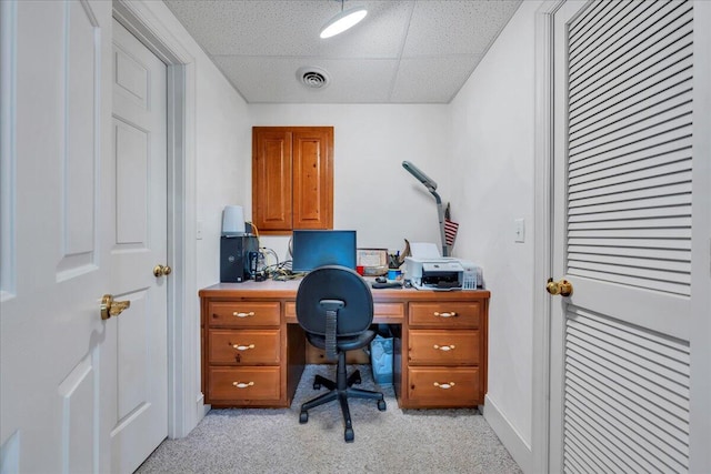 office with a paneled ceiling, visible vents, and light carpet