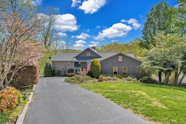 view of front of property with a chimney and a front lawn