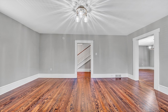 319 Trinity Rd, Troutville, VA 24175 - empty room featuring visible vents, baseboards, a notable chandelier, wood finished floors, and stairway