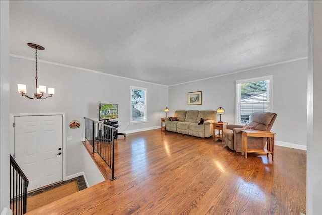 living room with a notable chandelier, wood finished floors, and plenty of natural light