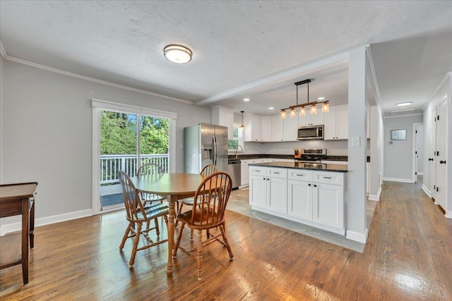 dining area with wood finished floors, crown molding, recessed lighting, and baseboards