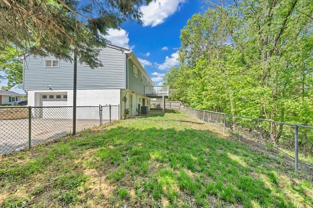 view of yard featuring driveway, central AC, an attached garage, and a fenced backyard