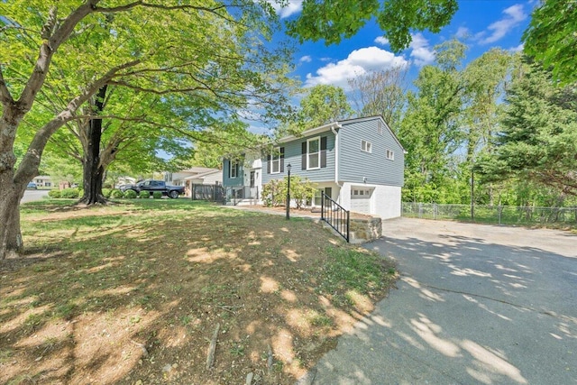 view of front of home with a garage, fence, and driveway
