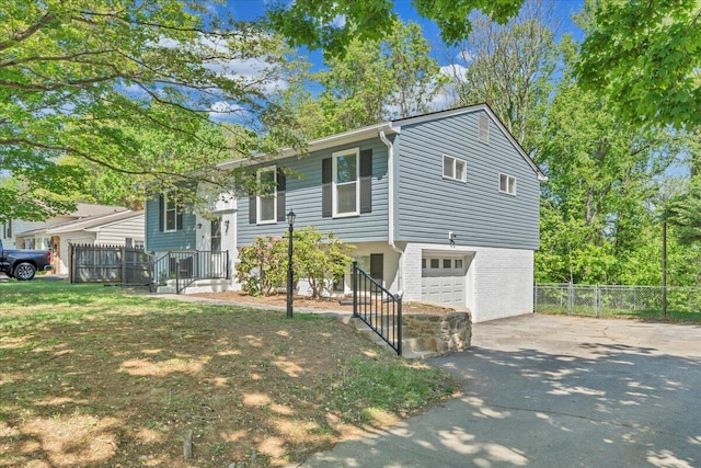 raised ranch with driveway, an attached garage, and fence