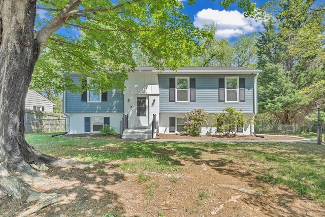 bi-level home featuring fence and a front lawn