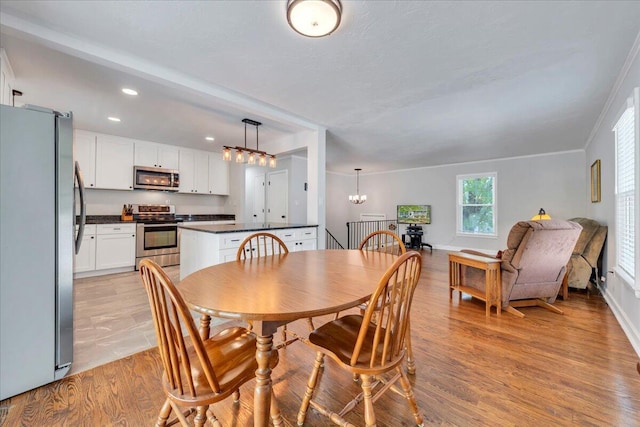 dining area with a chandelier, recessed lighting, and light wood-style flooring