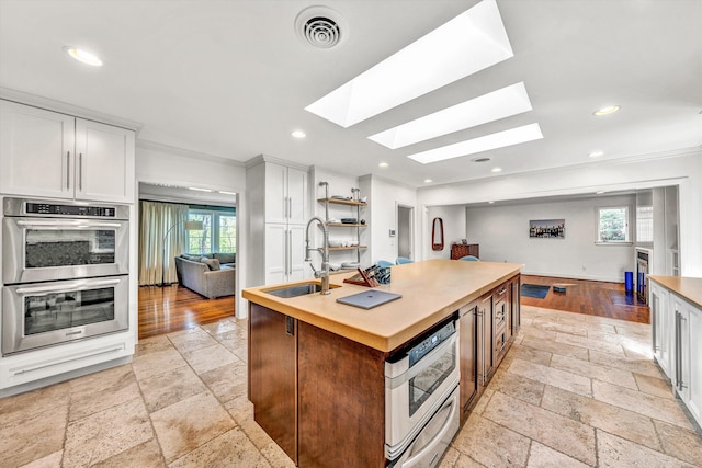 3421 Exeter St SW, Roanoke, VA 24014 - kitchen featuring double oven, stone tile floors, visible vents, a healthy amount of sunlight, and a sink