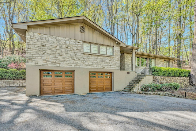 3421 Exeter St SW, Roanoke, VA 24014 - exterior space featuring stairway, driveway, stone siding, board and batten siding, and a garage