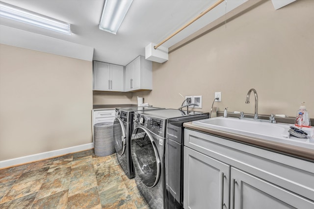 3421 Exeter St SW, Roanoke, VA 24014 - washroom with a sink, washing machine and dryer, baseboards, stone finish floor, and cabinet space